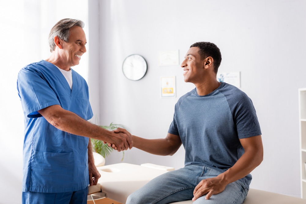 man shaking hands with medical professional