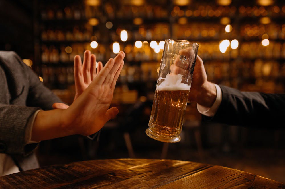 a hand refusing alcohol