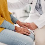medical professional holding the hand of an elderly person