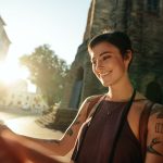 woman with short hair standing outside looking at a book