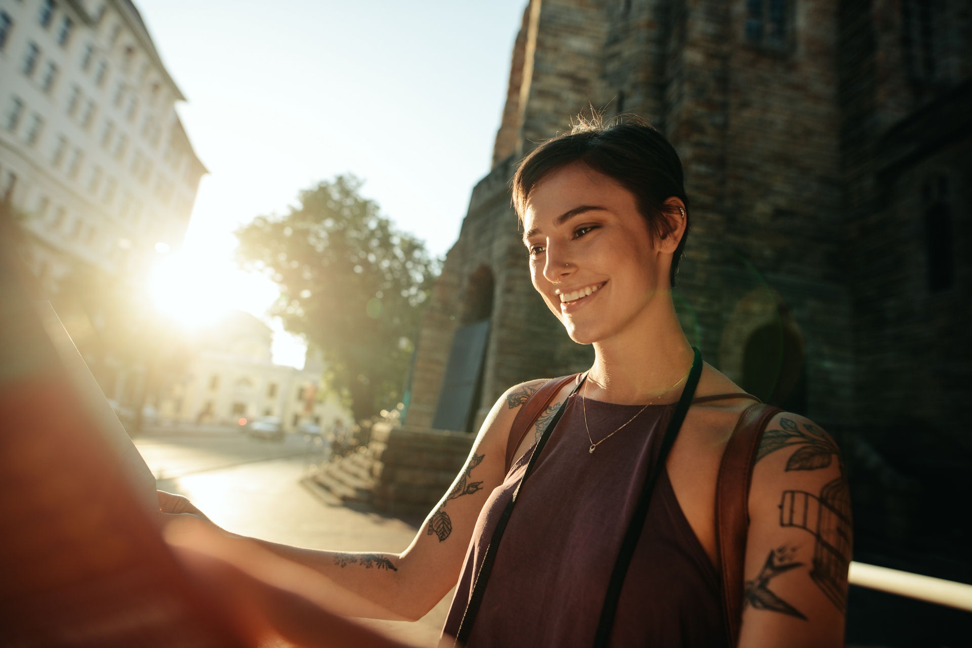 woman with short hair standing outside looking at a book