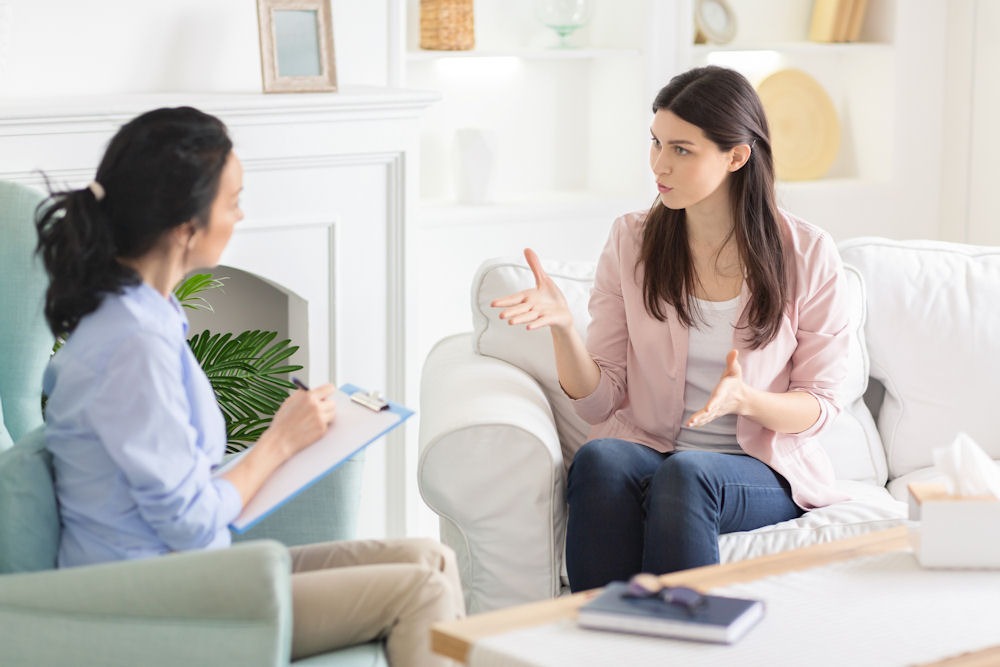 woman having a discussion with counselor who is taking notes on a clipboard