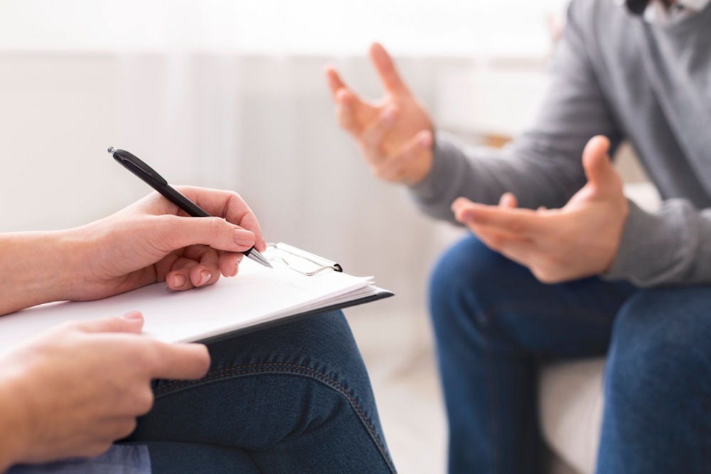 counselor taking notes while client talks