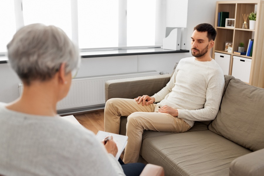 upset man sitting in individual therapy