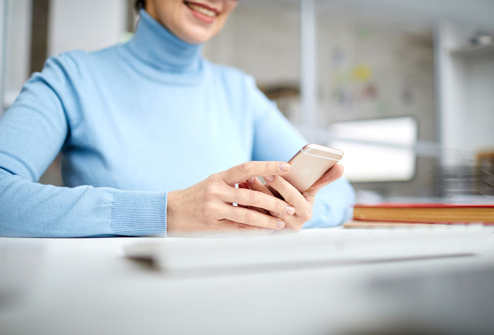 woman in blue using her phone to make a call