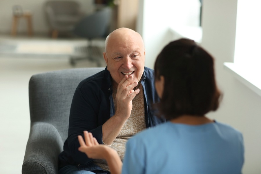 older man speaking with therapist and smiling