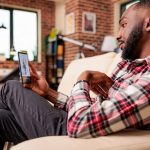 man sitting on chair with his phone