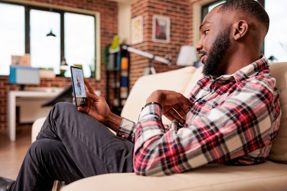 man sitting on chair with his phone