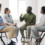 man speaking in group therapy session