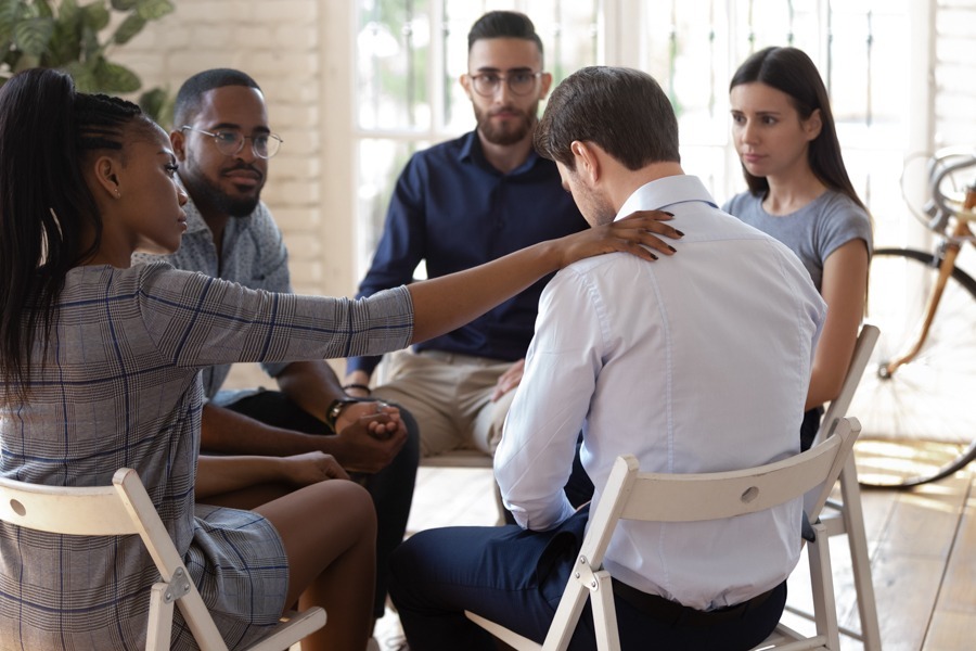 a man experiencing meth withdrawal getting comfort from group therapy