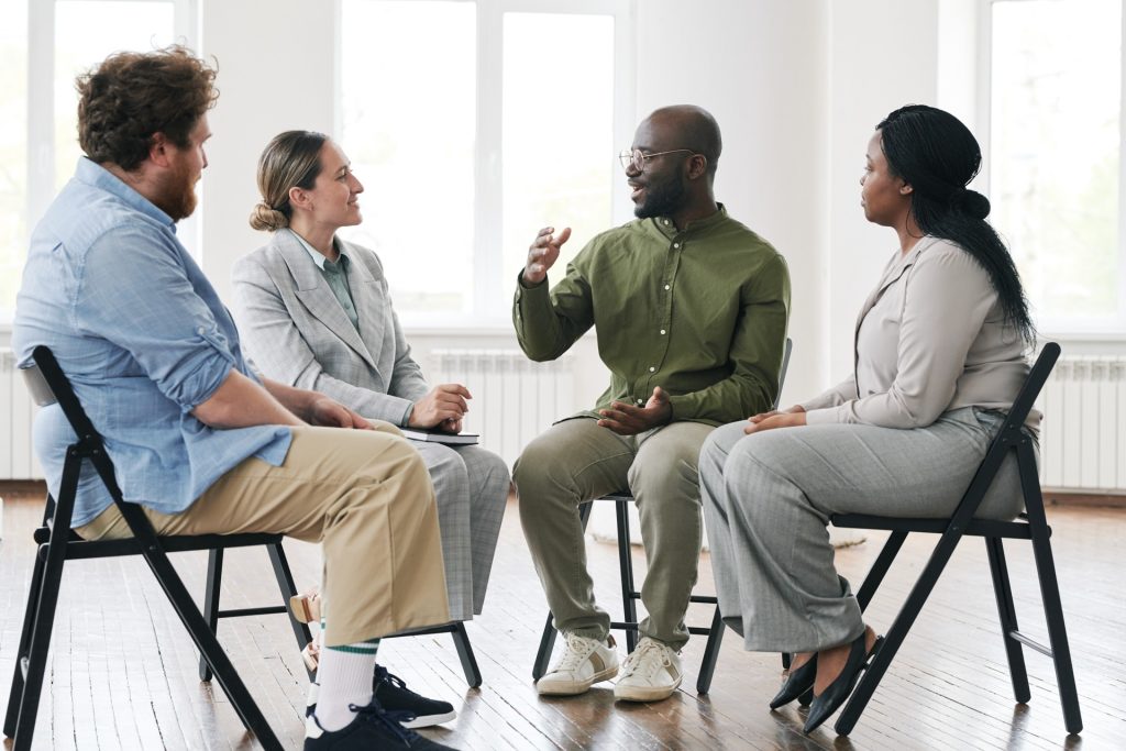 man speaking in group therapy session