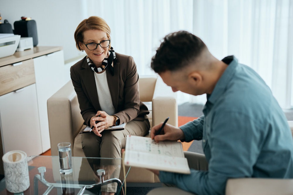 counsellor helping individual journal in recovery