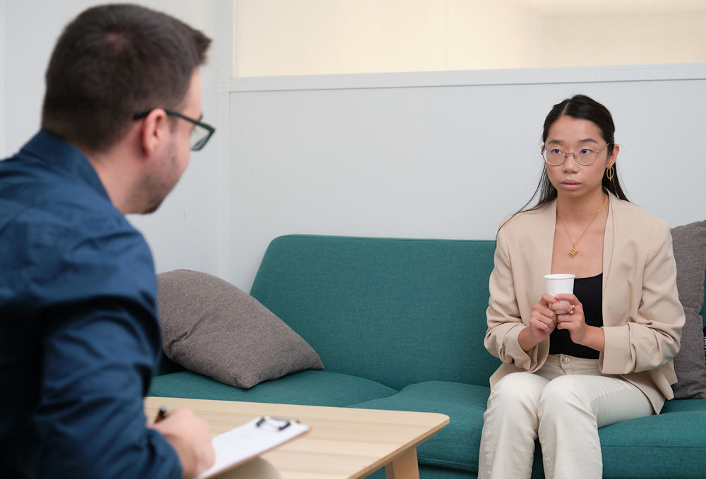 young woman sitting on green couch fro therapy