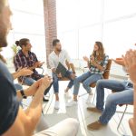 group therapy session with people sitting in chairs in a circle