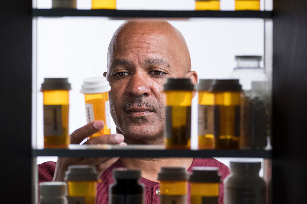 man looking at prescription pill bottles