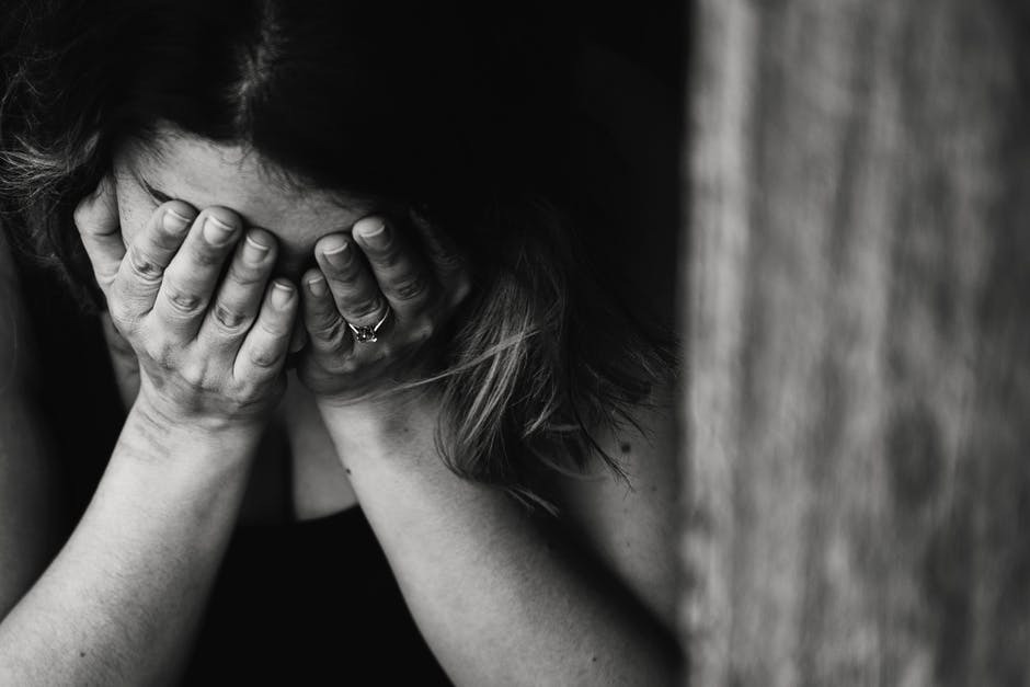 a woman covering her face with her hands