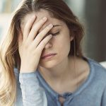 a woman holding her head showing sign of headache