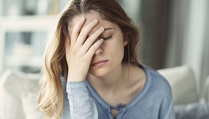 a woman holding her head showing sign of headache